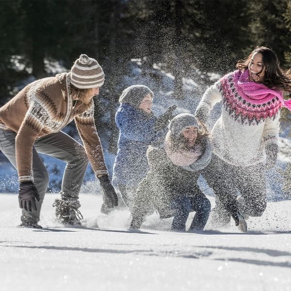 A family play with snow near Falkensteiner Hotel Sonnenalpe