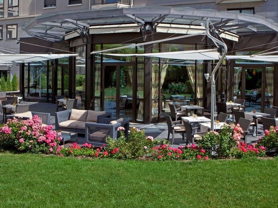 The Lounge Bar & Terrace with wicker chairs and tables, shaded by modern awnings at Warwick Reine Astrid - Lyon