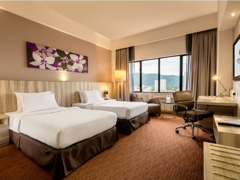 Two comfy beds and lounge in Deluxe Executive Room at Sunway Hotels & Resorts
