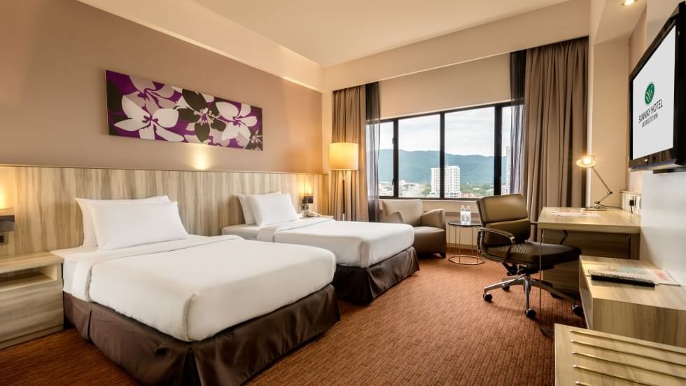 Two comfy beds and lounge in Deluxe Executive Room at Sunway Hotels & Resorts