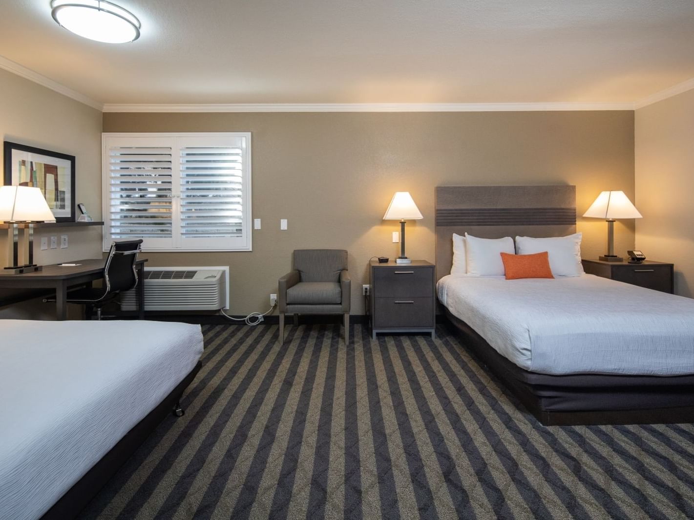 two beds and a desk in a hotel room
