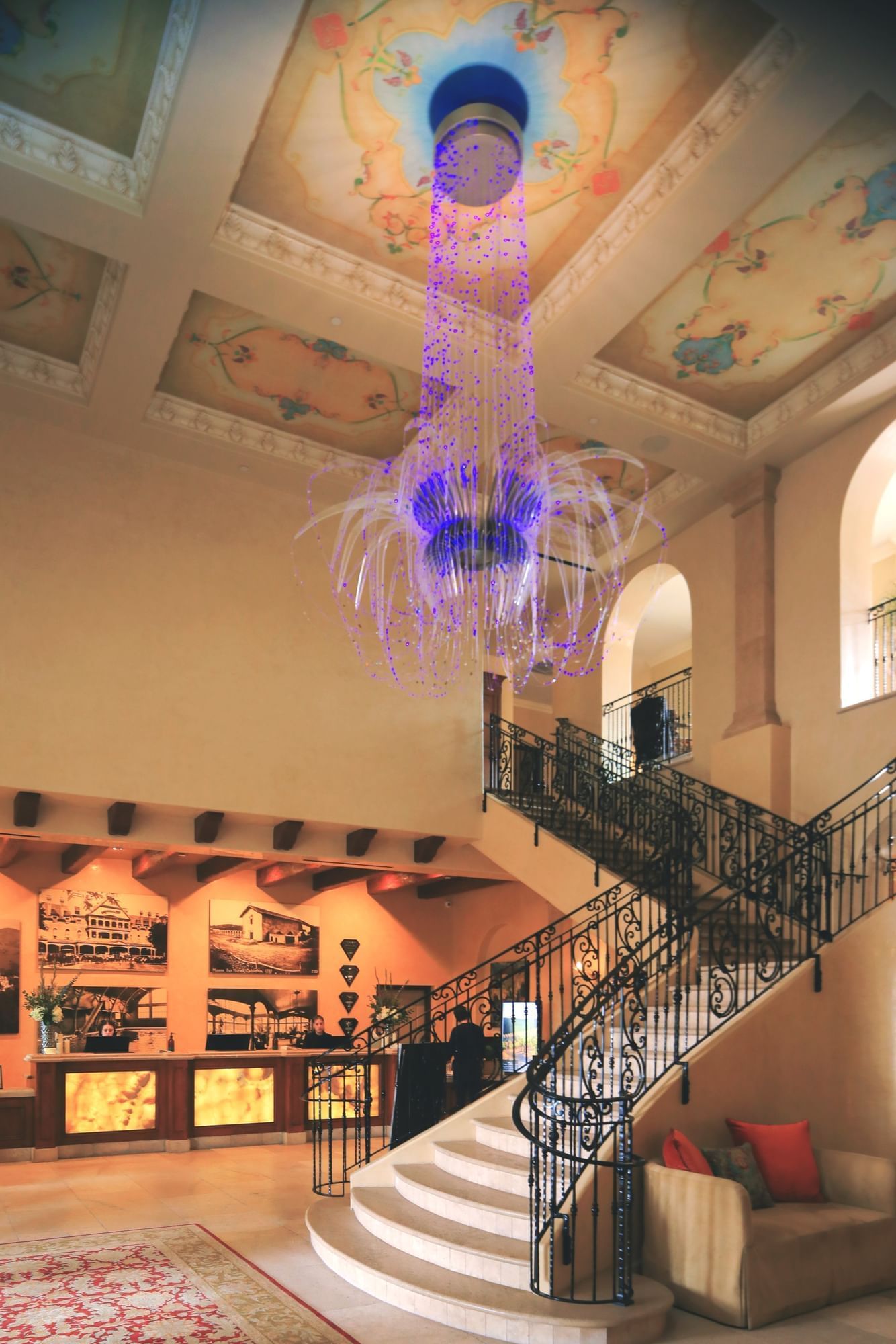 Lorem ipsum Hotel lobby with large chandlier, a staircase and reception desk