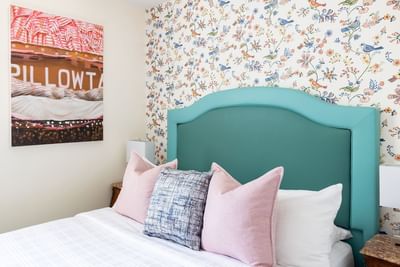 Cozy bed, nightstand & wall art in Queen Premiere at Retro Suites Hotel