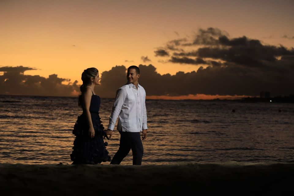 A couple walking at the beach in twilight near Club Hemingway