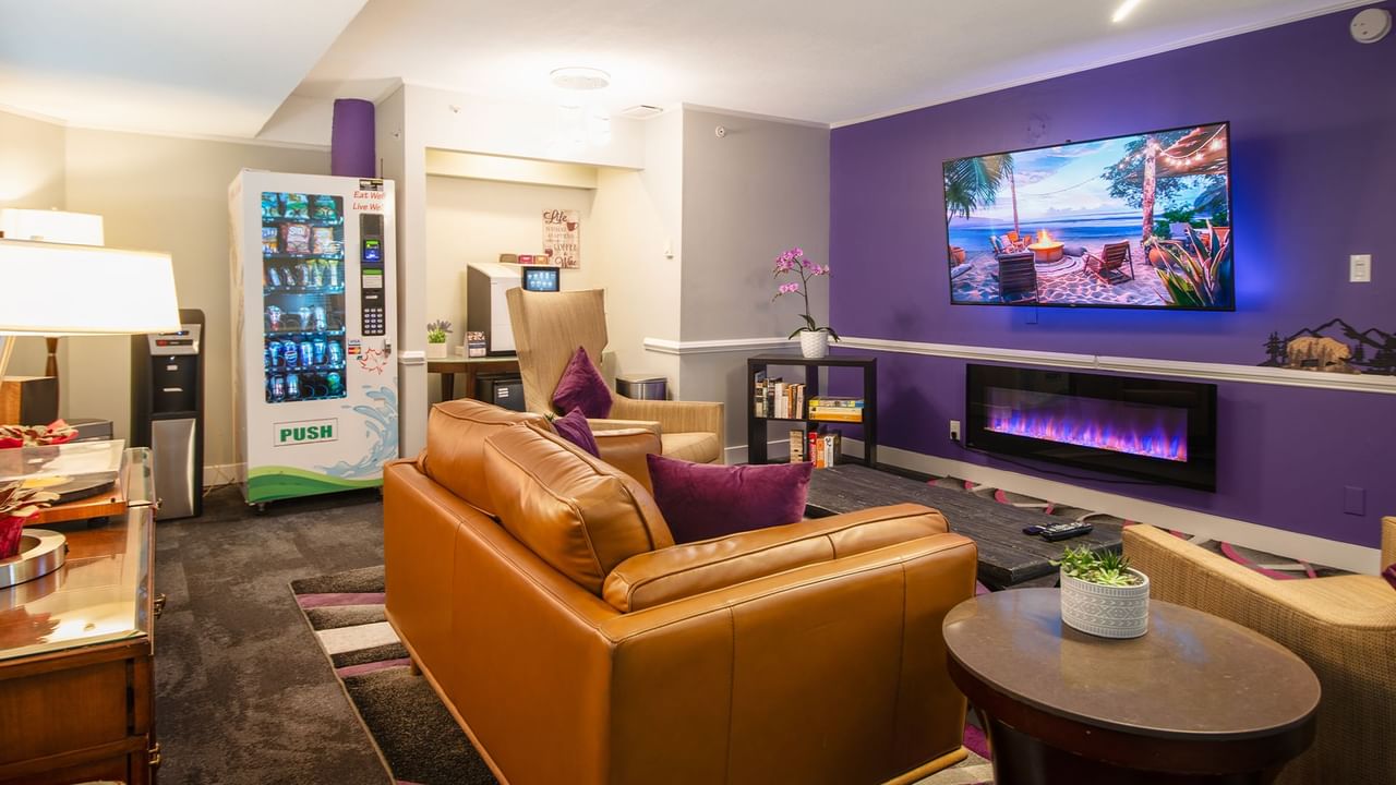 Lounge at Coast Parksville Hotel with chairs, tables, vending machine and TV