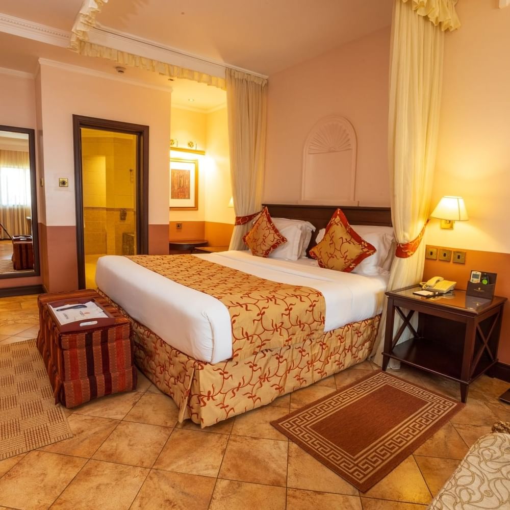 Elegant Executive Suite with large bed, desk, and decor at Lake Victoria Serena Golf Resort & Spa in Kampala.