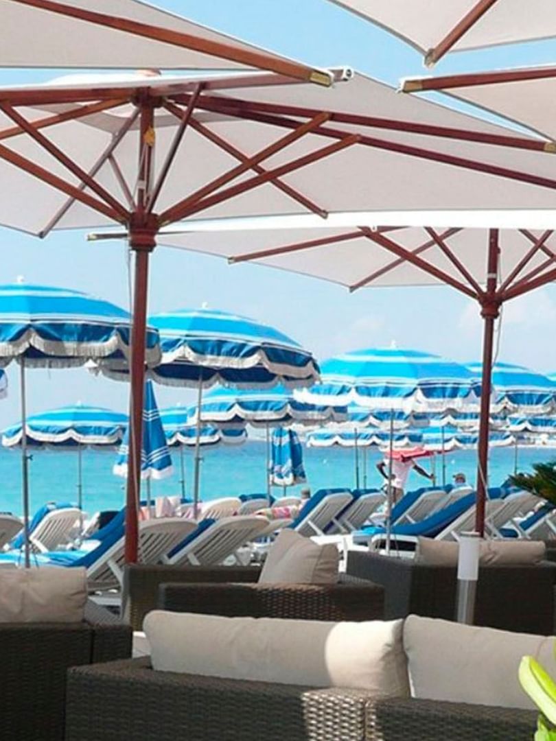 Chaises longues et parasols disposés sur la plage privée du Splendid Hotel & Spa Nice