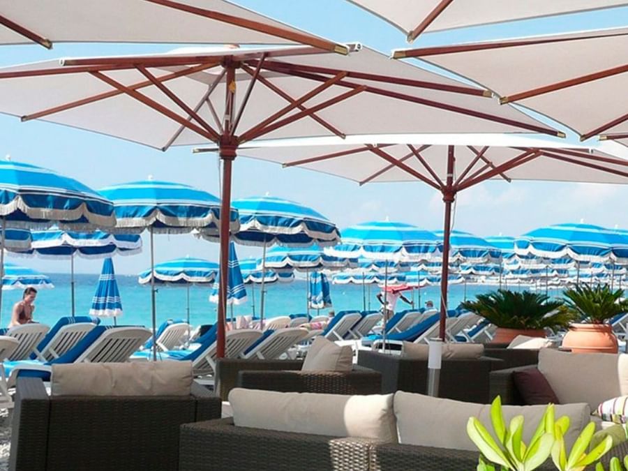Chaises longues et parasols disposés sur la plage privée du Splendid Hotel & Spa Nice