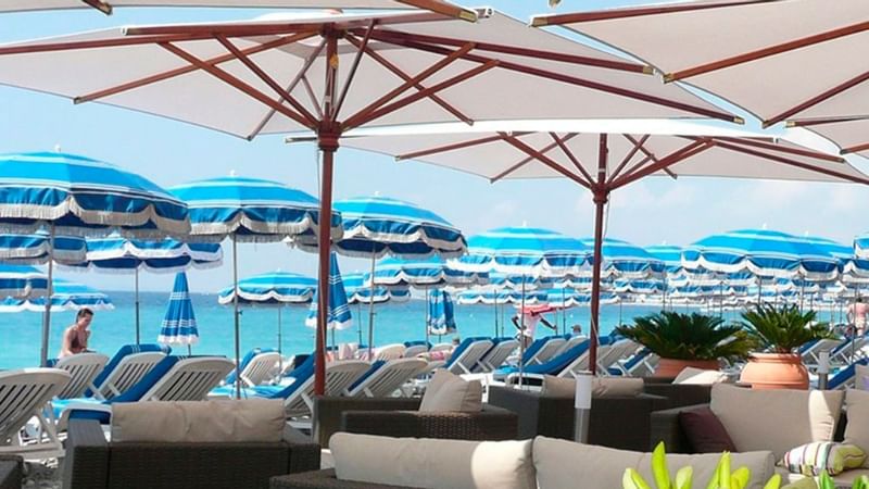 Sun lounges and umbrellas arranged on the private beach at Splendid Hotel & Spa Nice