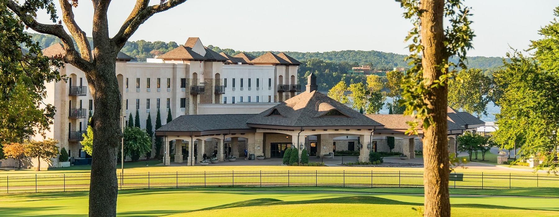 Scenic view of the Shangri-La Resort hotel building from the lush green golf course at Grand Lake under a clear blue sky