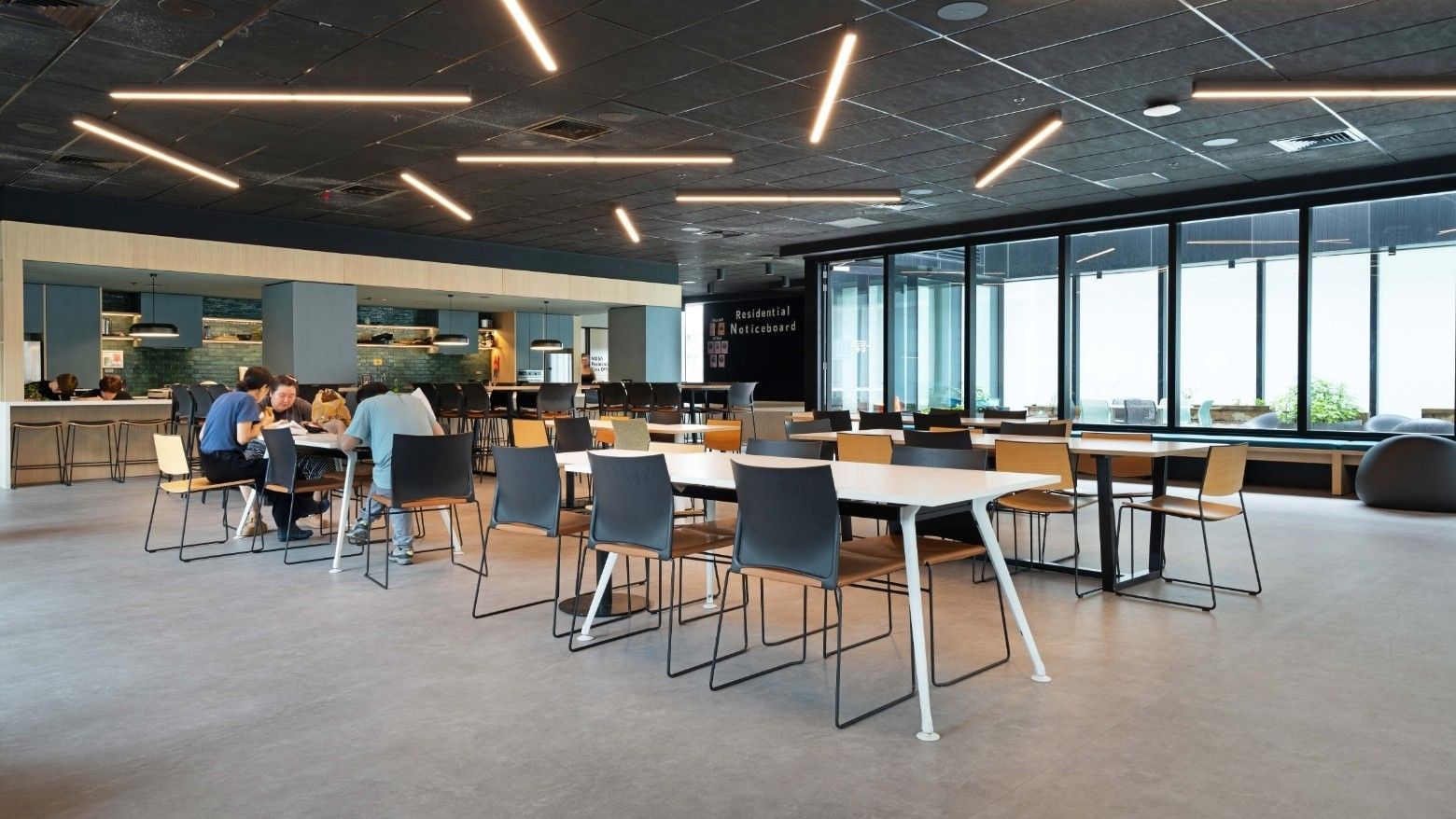 Modern student accommodation dining area with tables and chairs at Mayoral Drive.