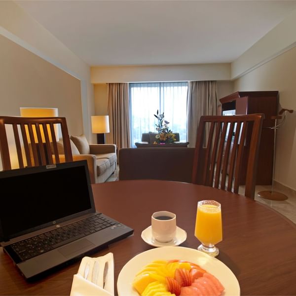 Laptop & breakfast on a table in Junior Suite at Fiesta Inn