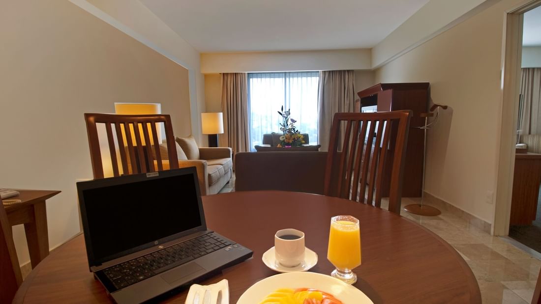 Laptop & breakfast on a table in Junior Suite at Fiesta Inn