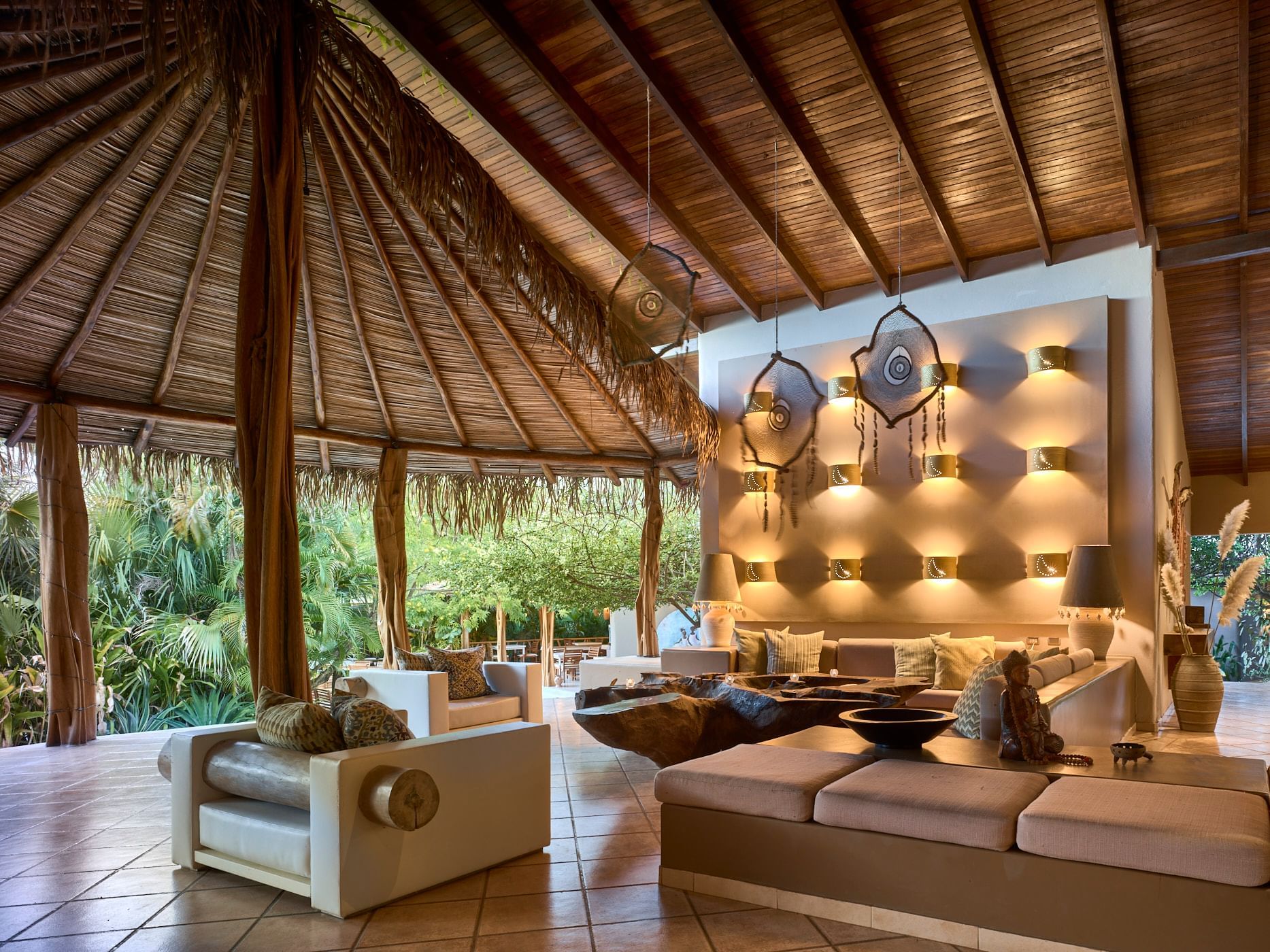 Rustic-chic lobby featuring high thatched ceilings and unique handcrafted decor at Cala Luna Boutique Hotel