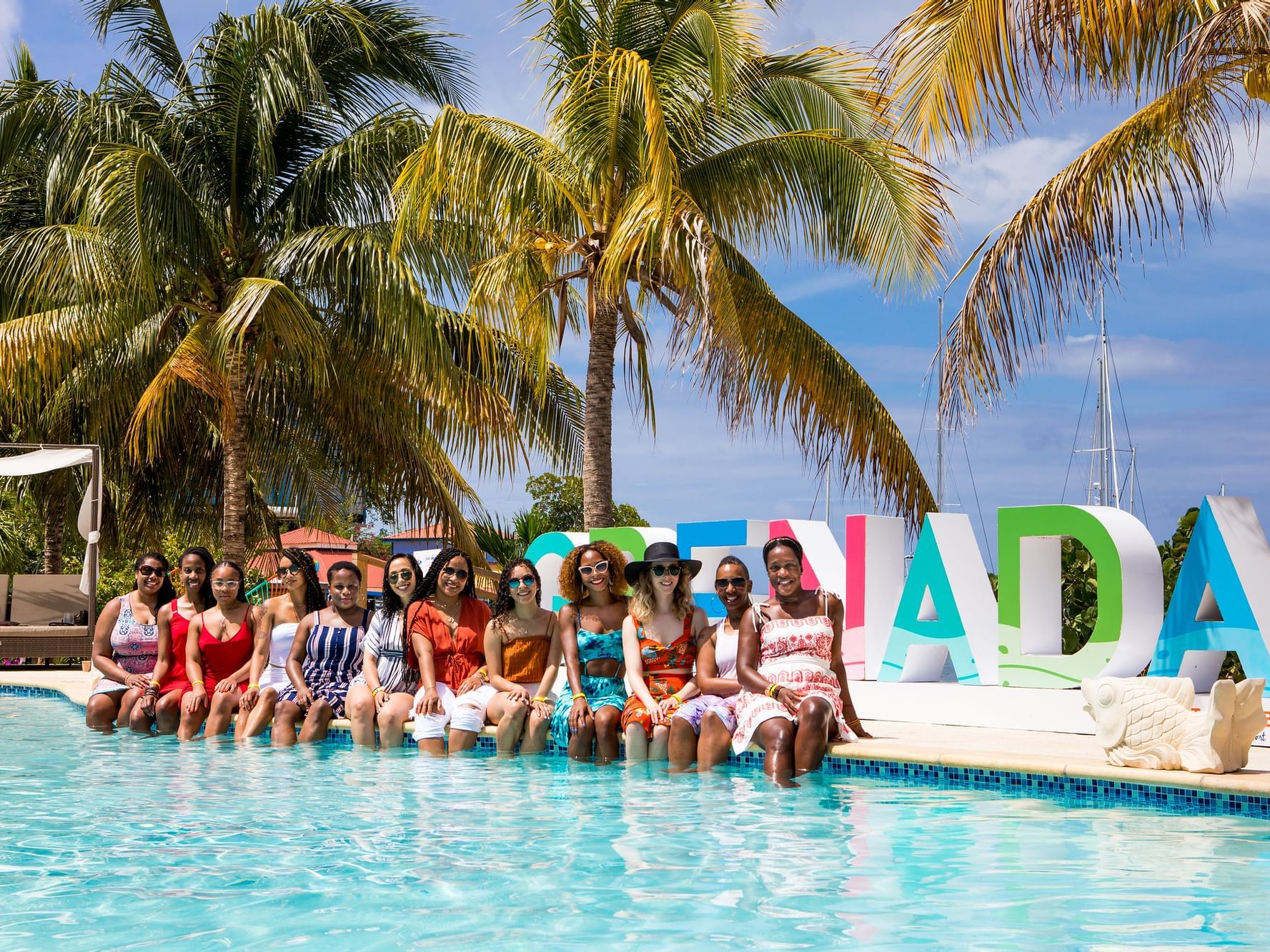 Ladies posing for a photo by the pool at True Blue Bay Resort