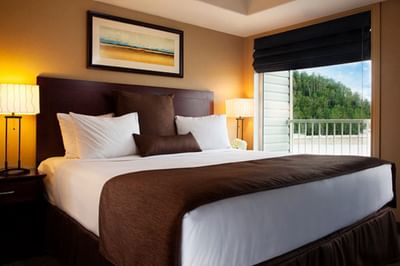 King bed by a picture window in Studio King Riverview at Franklin Suite Hotel