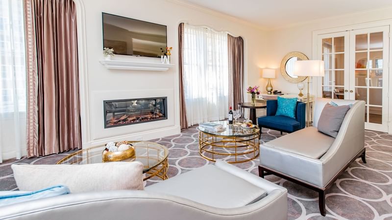 Presidential Suite room featuring a fireplace, a TV, stylish furniture, and large windows at Warwick Melrose Dallas