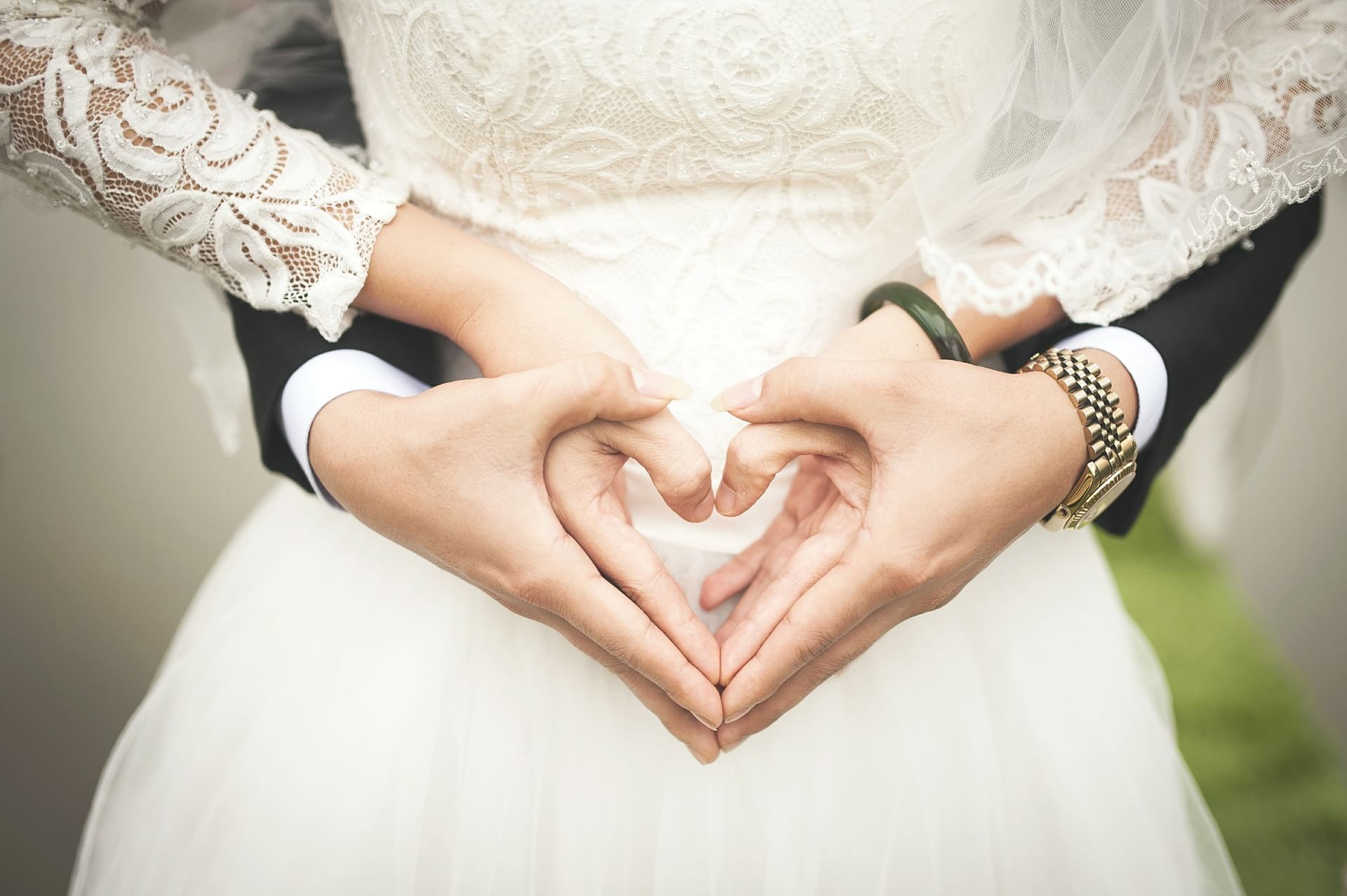 A bride & groom forming a heart shape with their hands at Eastin Easy Vita
