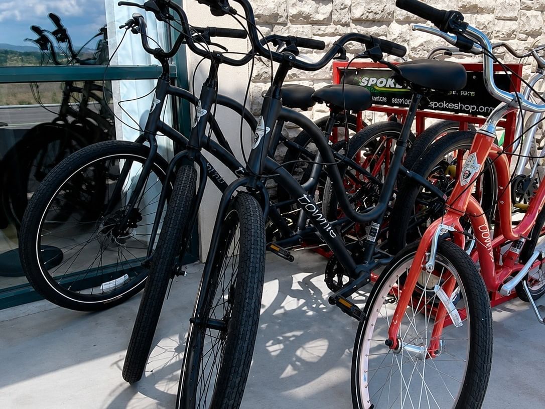 Complimentary bicycles parked on an outdoor terrace with stone wall backdrop at Booking - Boothill Inn