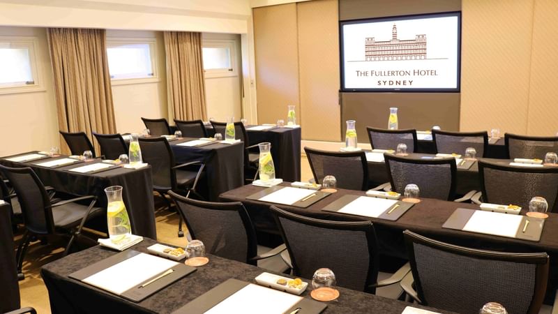 Classroom table set-up with a digital screen in a meeting room at Fullerton Hotel Sydney