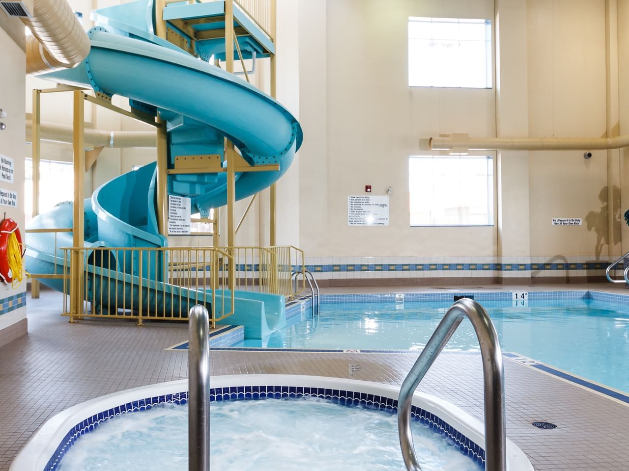 Indoor pool with waterslide and hot tub at The Glenmore Inn & Convention Centre