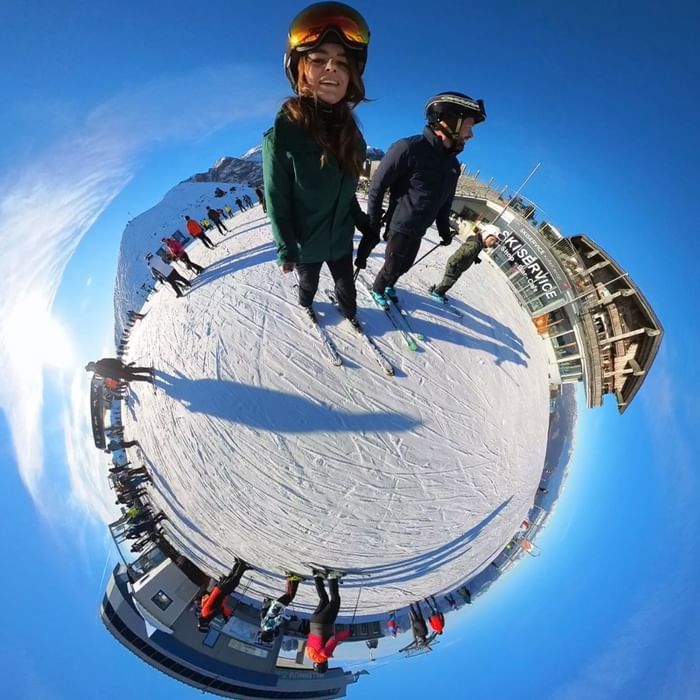 Vista panoramica di sciatori sulla neve con struttura di servizio visibile at Falkensteiner Group