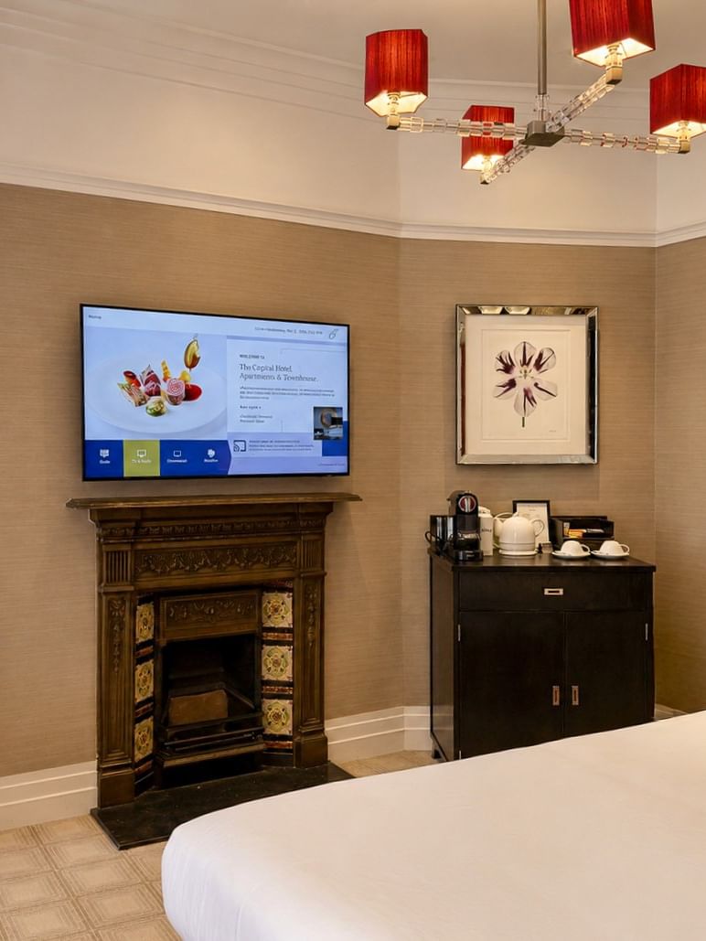 Deluxe King room with fireplace, desk, TV, and coffee station at The Capital Hotel, Apartments & Townhouse in London.