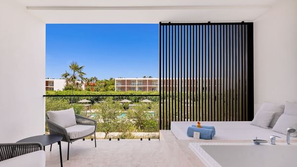 Bathtub by the spa bed and seating area in Premium Deluxe Pool View room at Live Aqua Punta Cana