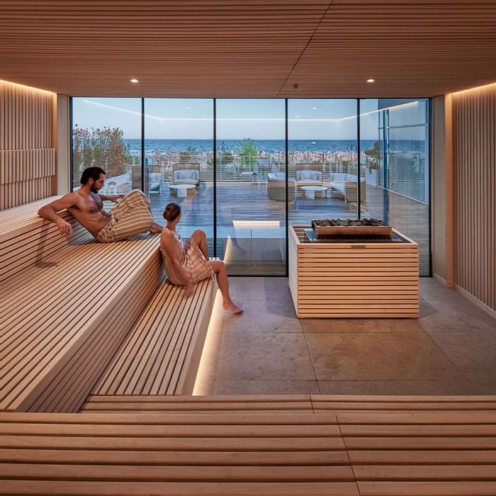 A couple relaxing in a Finnish sauna at Falkensteiner Hotels