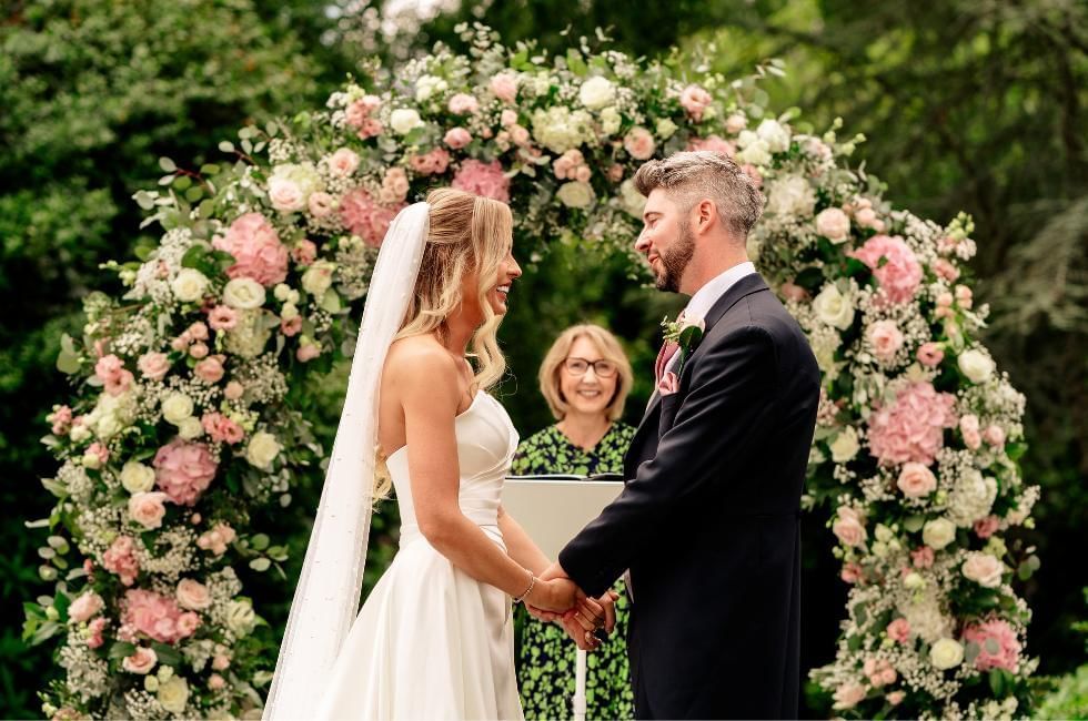 Bride and groom holding hands during outdoor wedding ceremony at  at Gorse Hill, offering amazing Wedding Fairs in Surrey