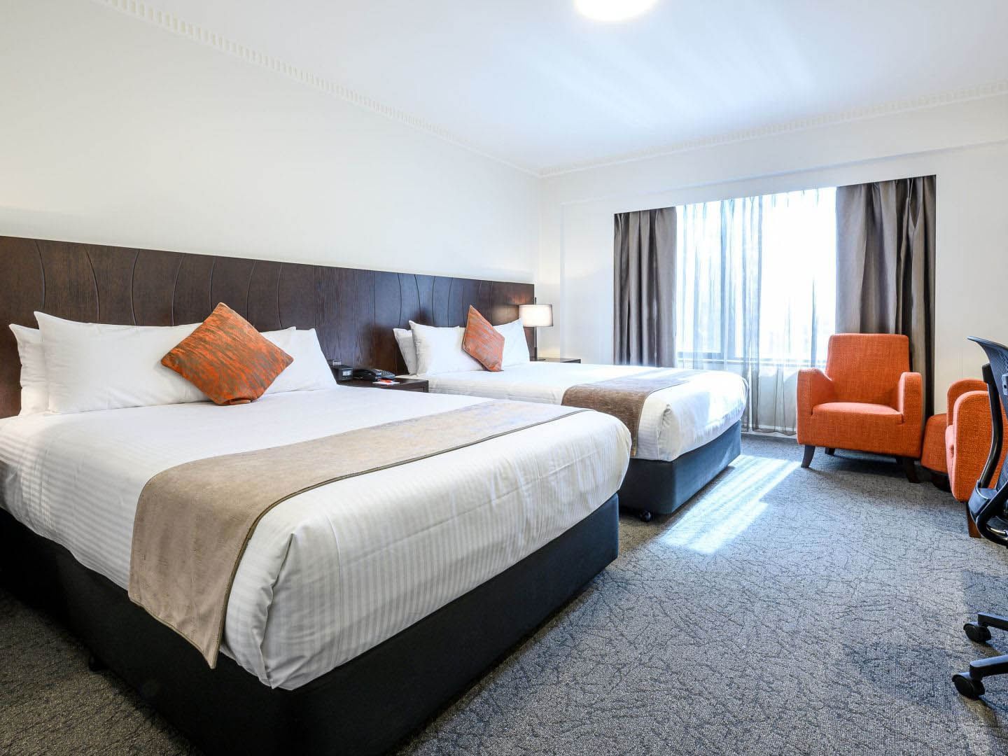 Beds with working table and sofas in Executive Twin Room at Hotel Grand Chancellor Adelaide