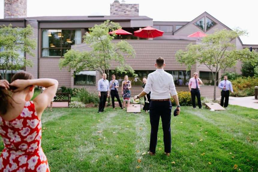 Guests playing cornhole on the lawn during an outdoor event at Aramark Chauncey Conference Center