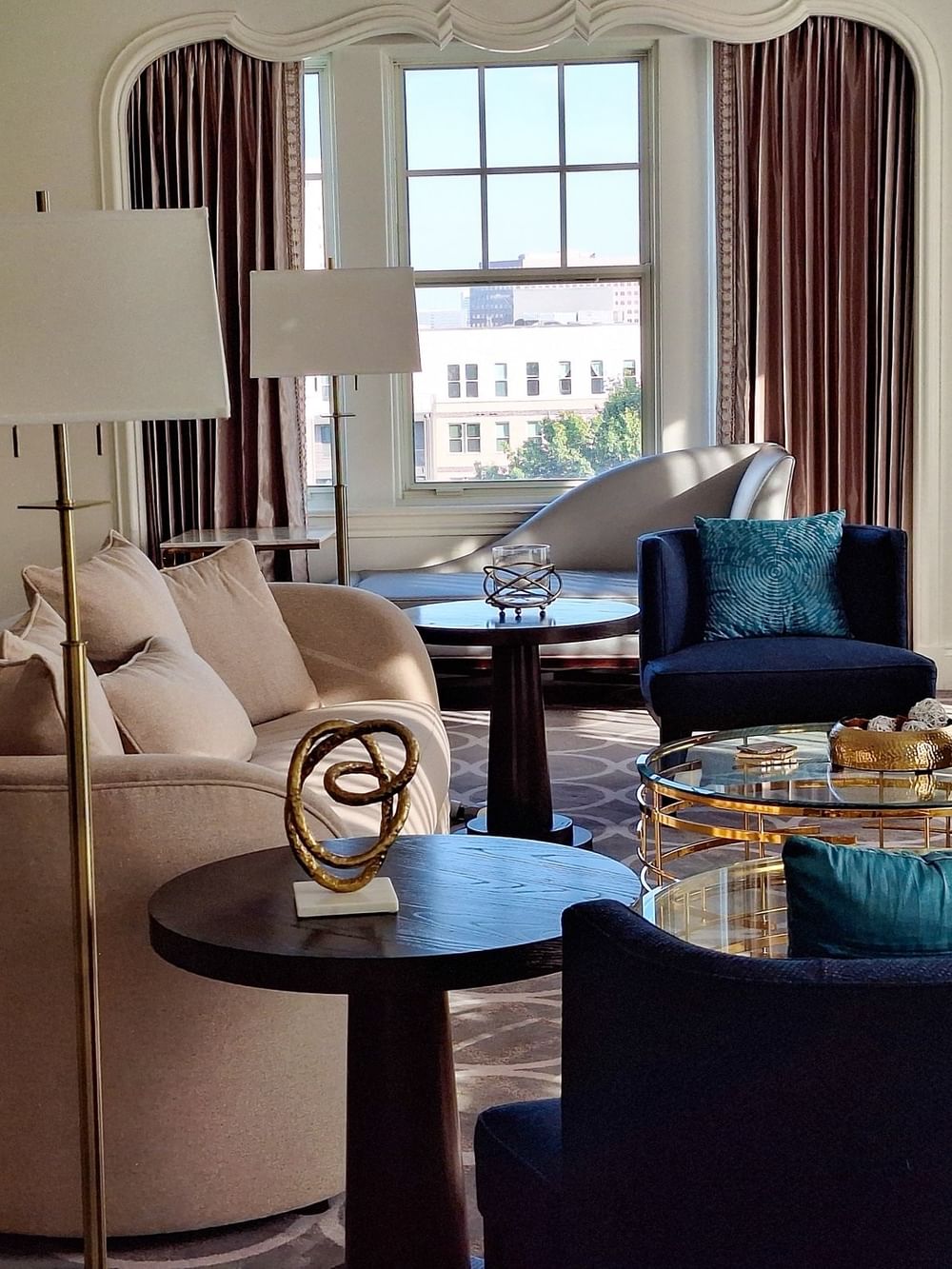 Elegant seating area with a beige sofa and teal chairs in the Presidential Suite at Warwick Melrose - Dallas.