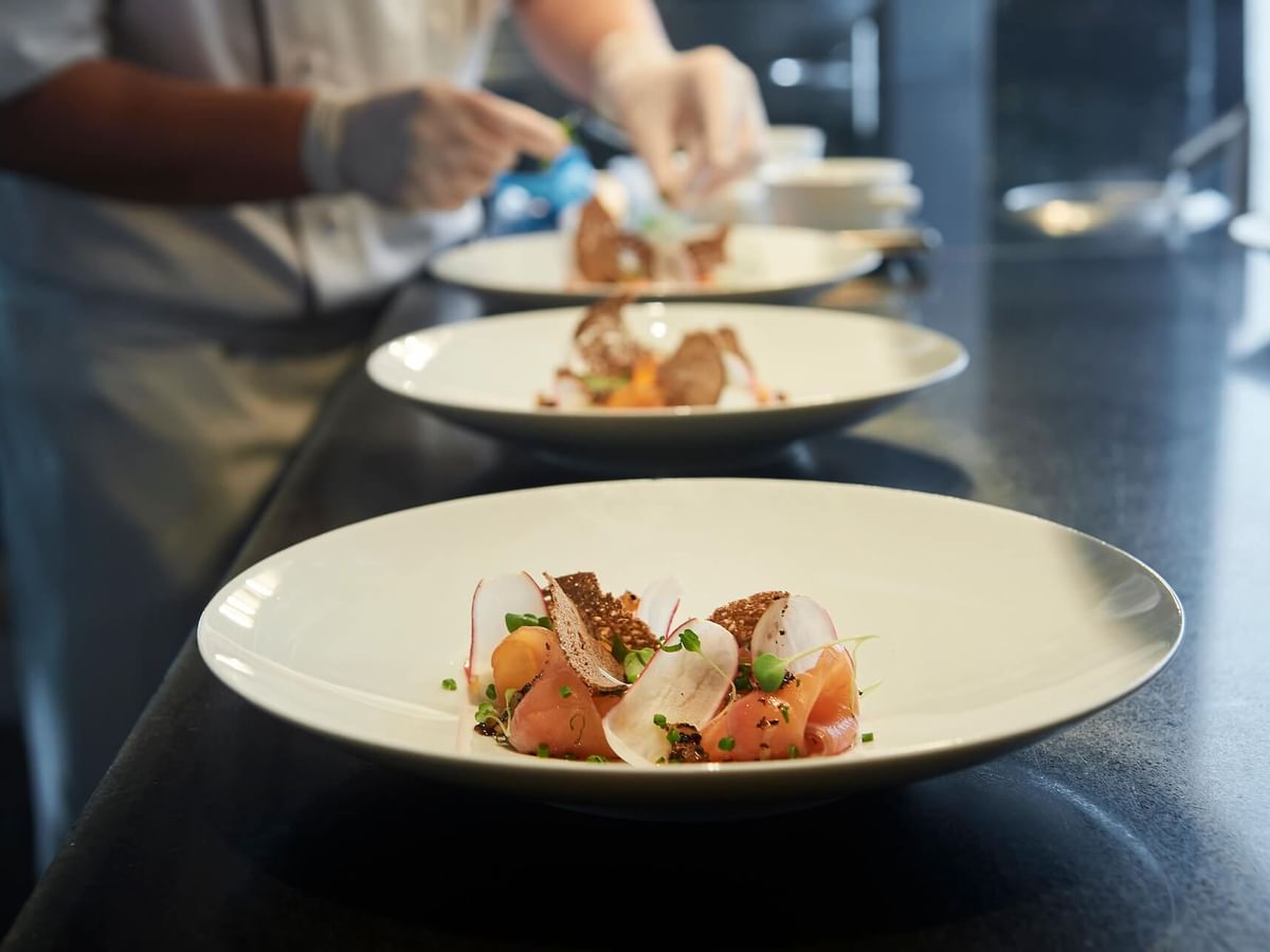 A Chef garnishing dishes in Evergreen at Crown Hotel Melbourne