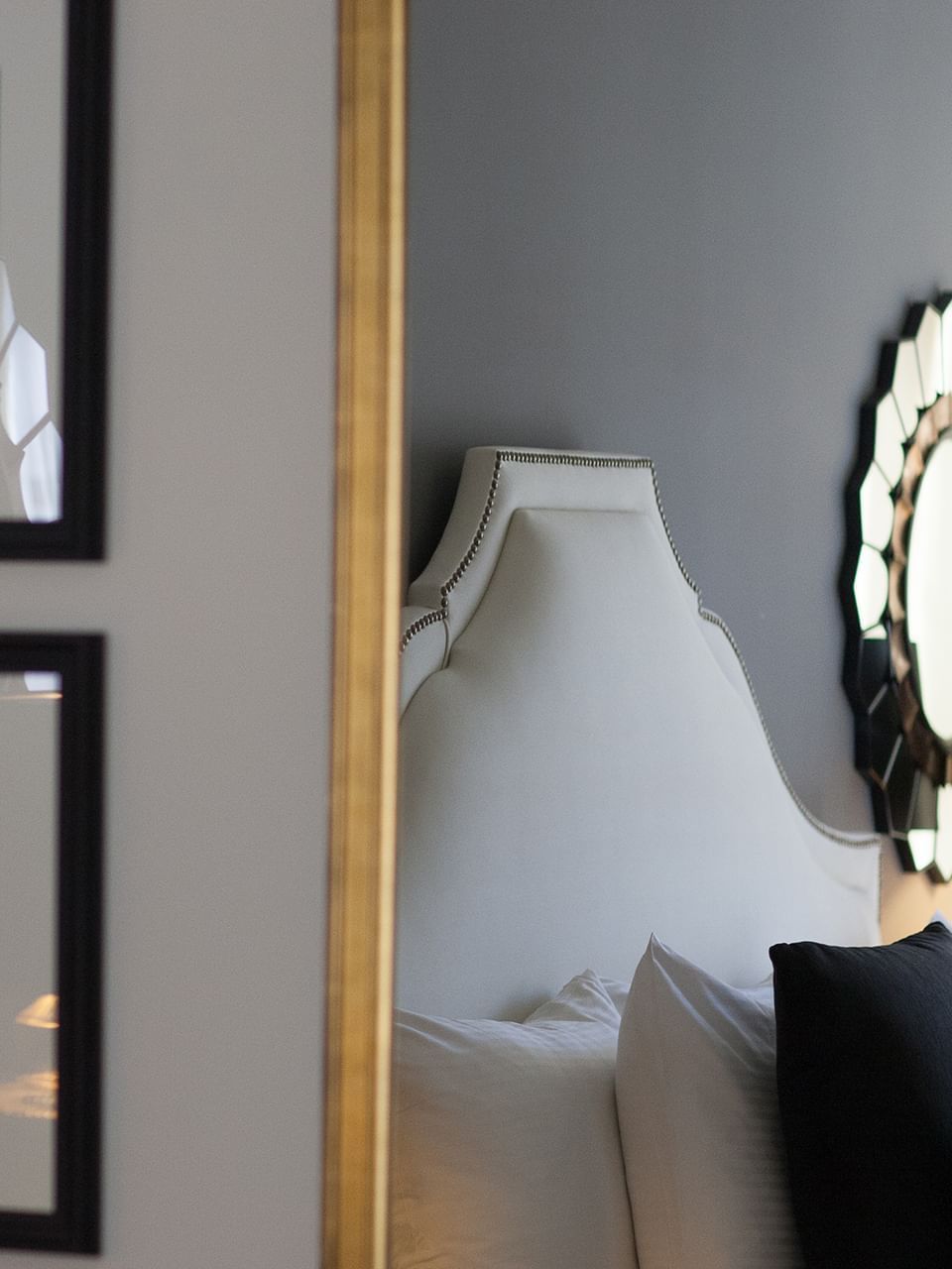 Marion Suite with a white headboard placed by black pillows under a wall art at Warwick New York 