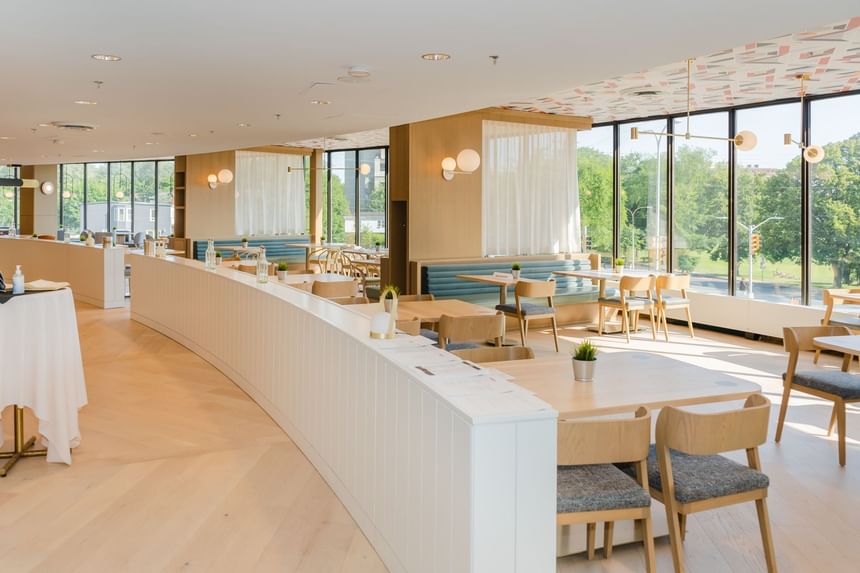 Cannery Restaurant at Nova Scotia with large windows, wooden floors, and a curved white counter with tables and chairs.