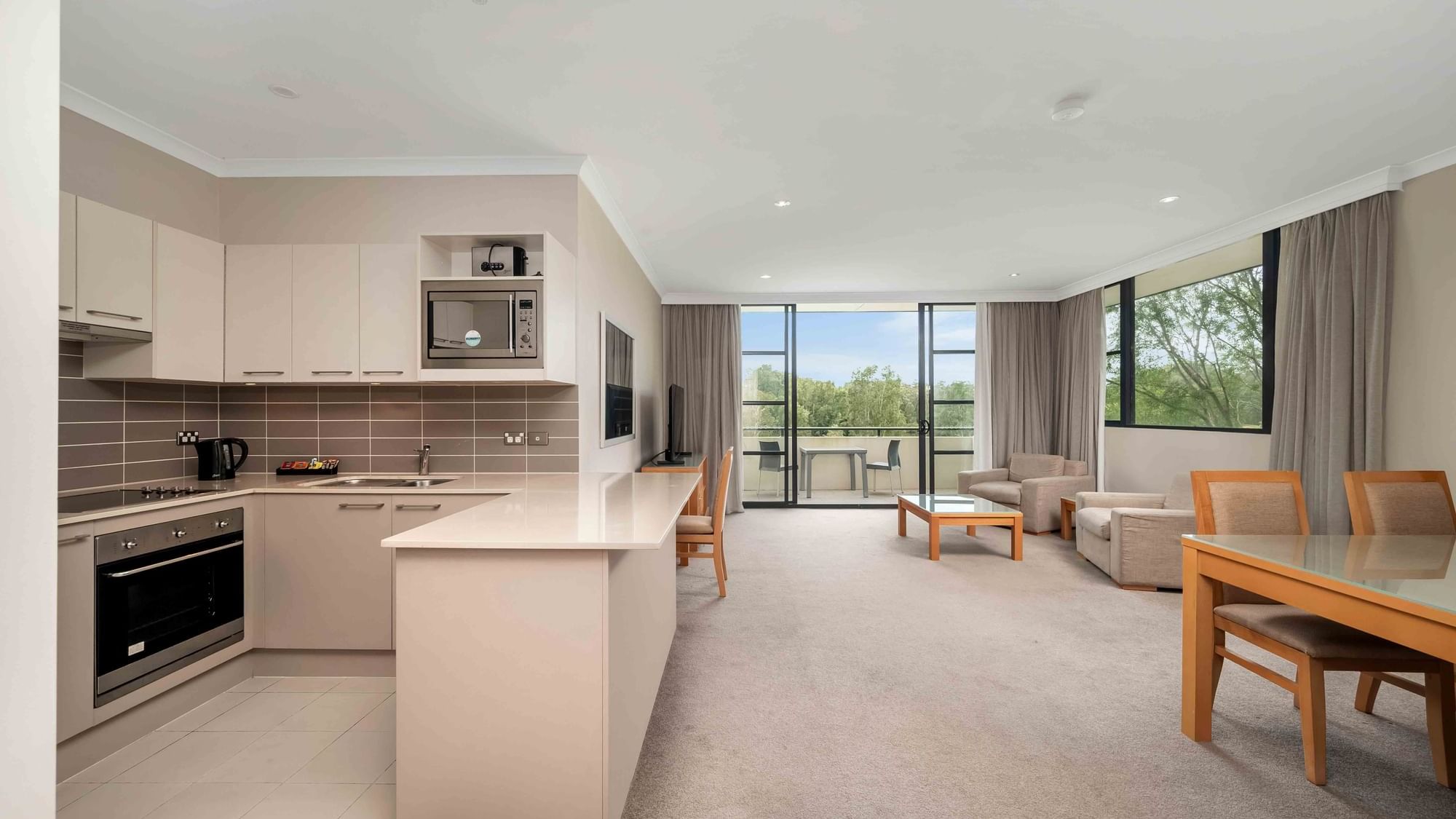 kitchen, dining and living are in a deluxe apartment with a balcony