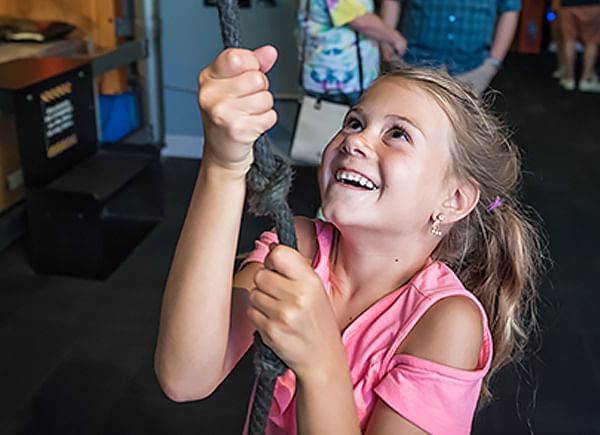 Child doing a physical activity at WonderWorks near Lake Buena Vista Resort Village & Spa