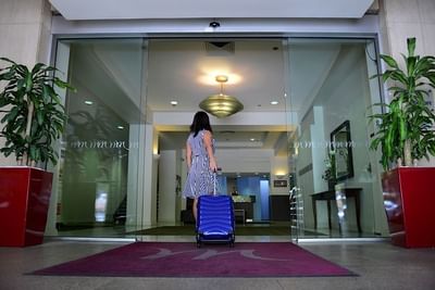 A lady with a luggage going inside the entrance of Grosvenor Hotel Adelaide