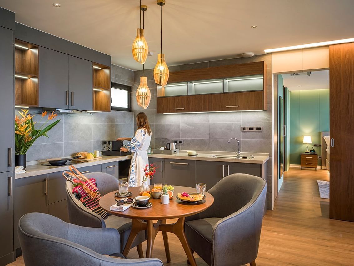 Woman preparing breakfast in the modern kitchen of Golden Rock Suite at Golden Rock Resort