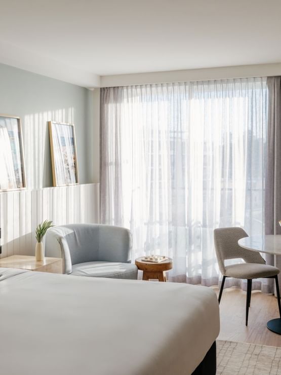 Sunset View King at Elysium Manly with a lemon bowl on a round marble table by sheer curtains under a light blue armchair
