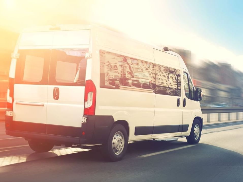 White van driving down the road in dawn near Fiesta Americana