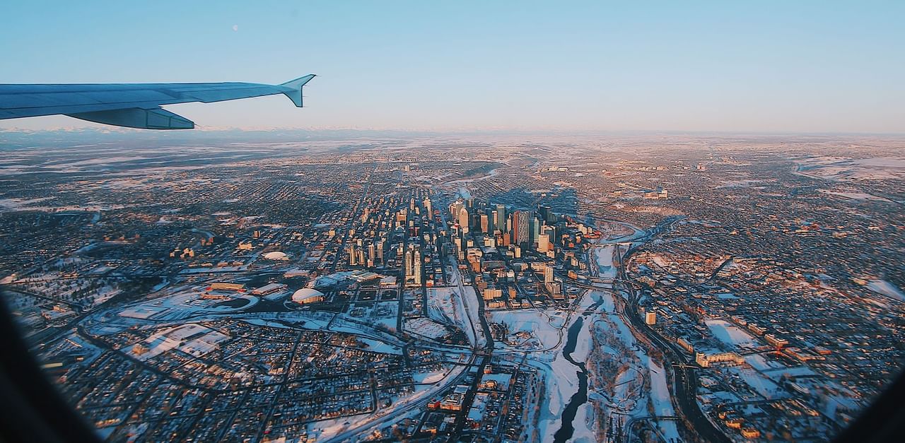 Aerial view of plane wing with city at near Coast Calgary Downtown Hotel