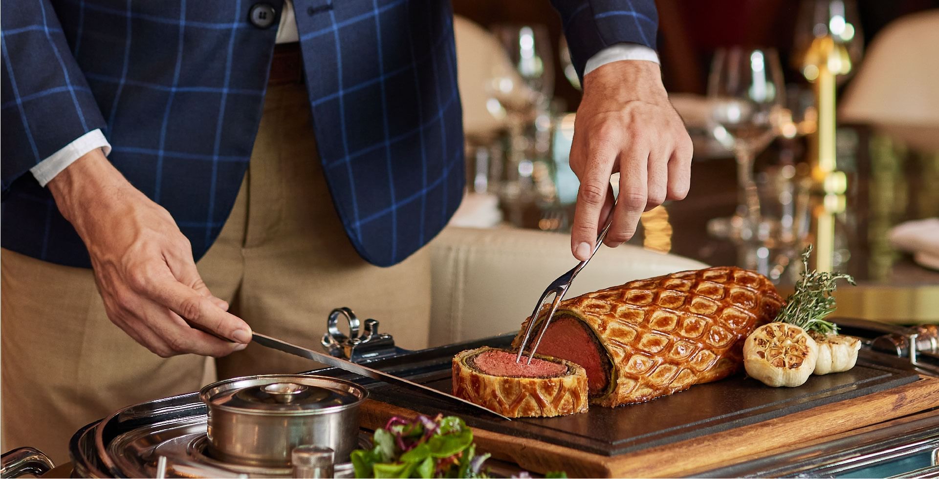 Chef carving a perfectly cooked Beef Wellington at a restaurant at Sunway Hotel Pyramid, showcasing fine dining