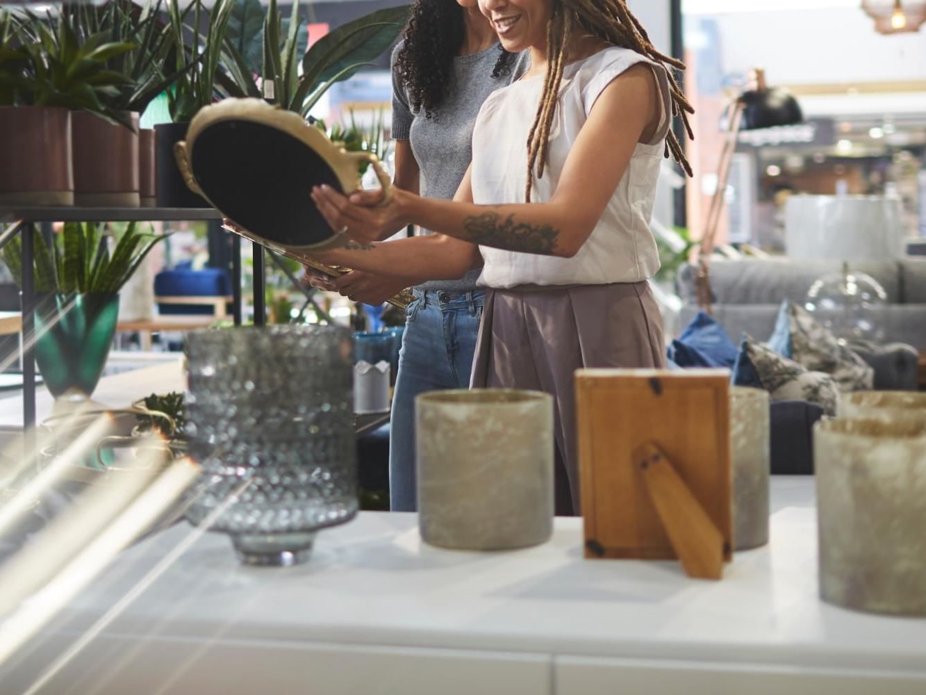 Two women looking at various plants and decorative items on a table in Boutique Shopping near Meadowmere Resort