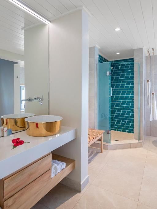 Elegant bathroom with dual copper sinks, white bathtub, and blue-tiled shower at Warwick Le Lagon - Vanuatu, Efate.