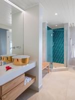 Elegant bathroom with dual copper sinks, white bathtub, and blue-tiled shower at Warwick Le Lagon - Vanuatu, Efate.