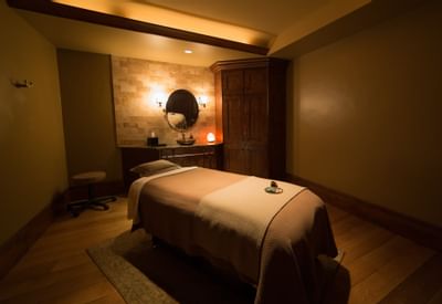 A treatment room with a bed in the Spa at Stein Eriksen Lodge