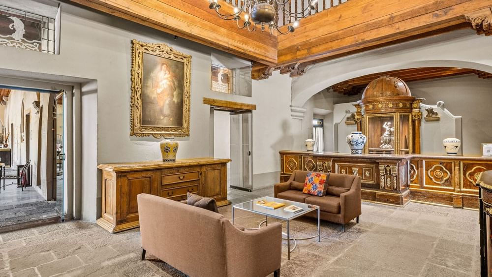 Boutique hotel lounge featuring vaulted arches, religious oil paintings, and antiques at Quinta Real Puebla
