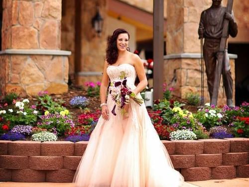 A bride in a beautiful pink dress at the outside of Stein Lodge